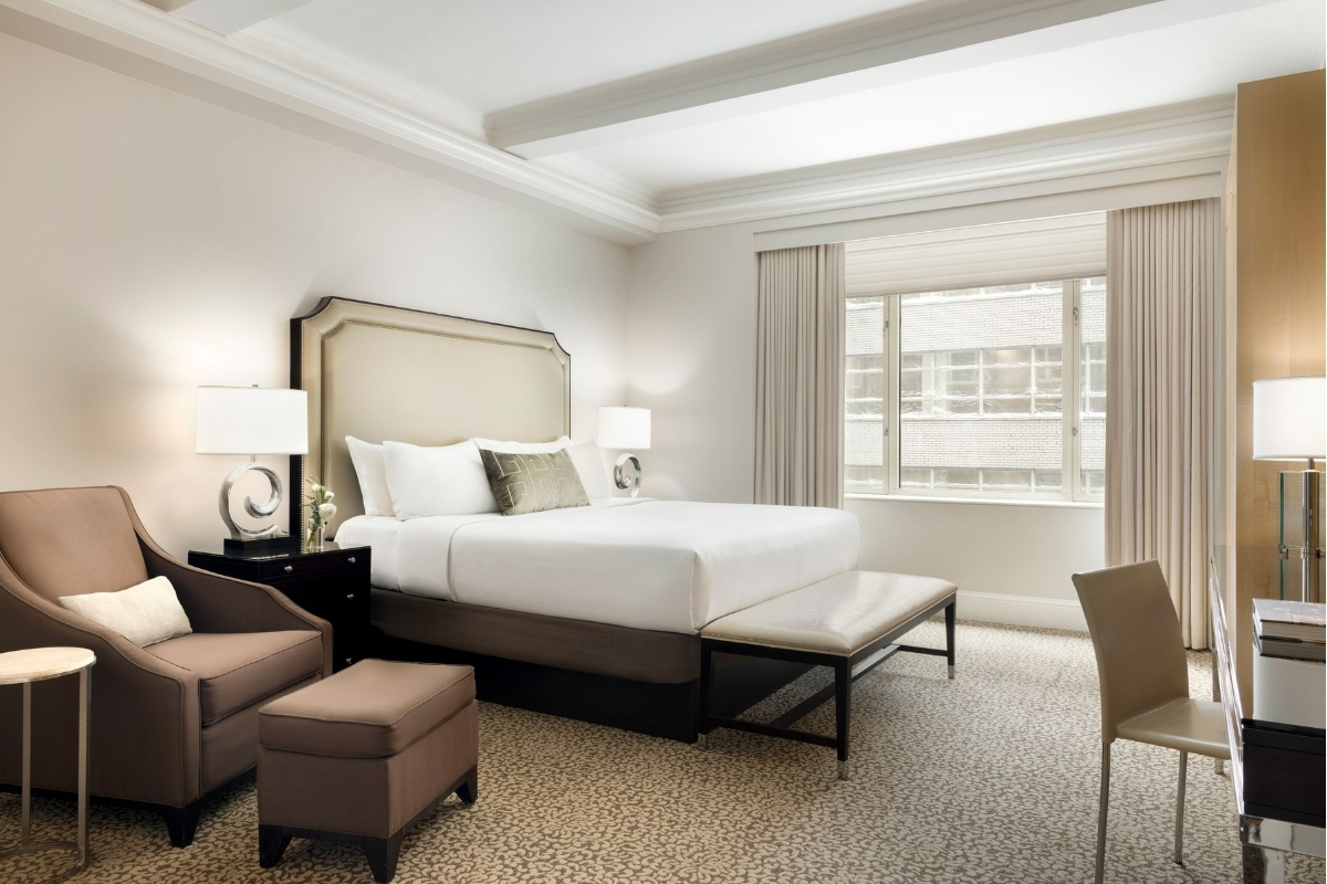 a bedroom with a bed and chairs