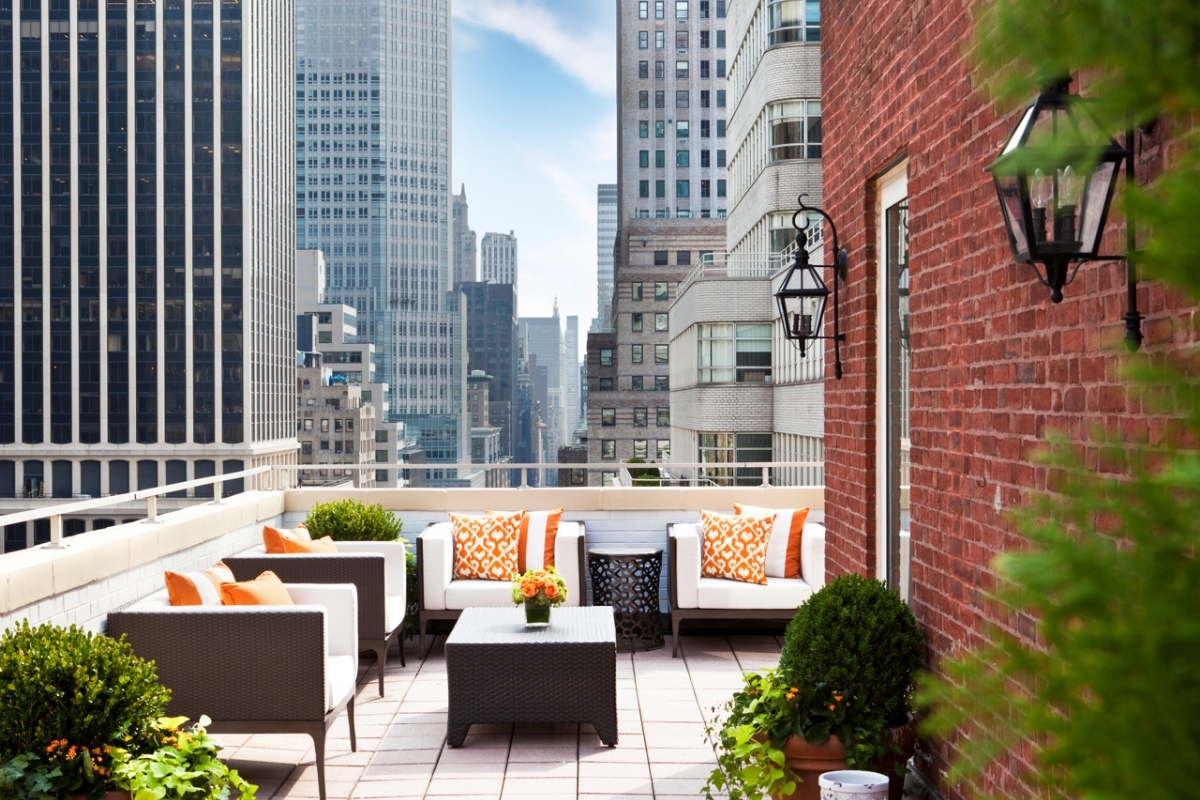 a patio with chairs and a table in front of a city