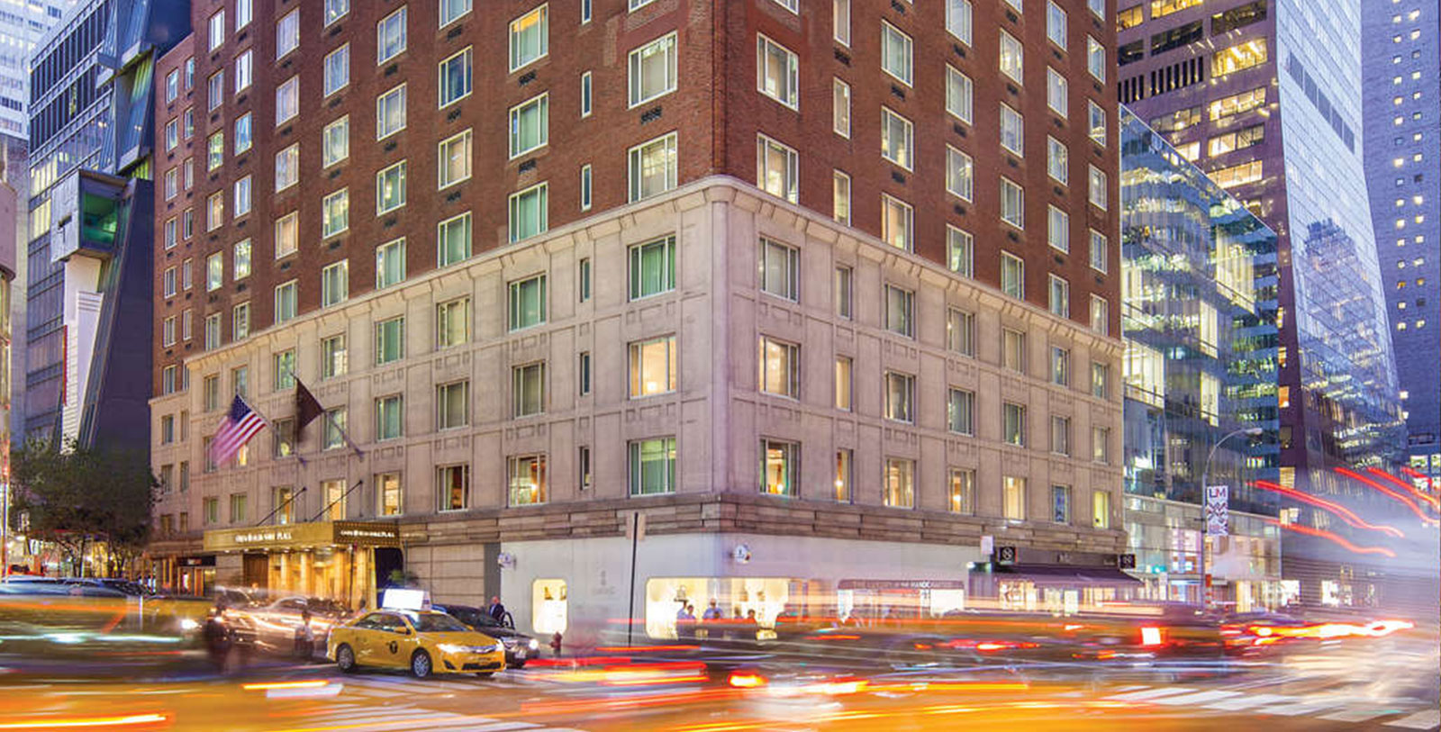 a building with many windows and cars on the street