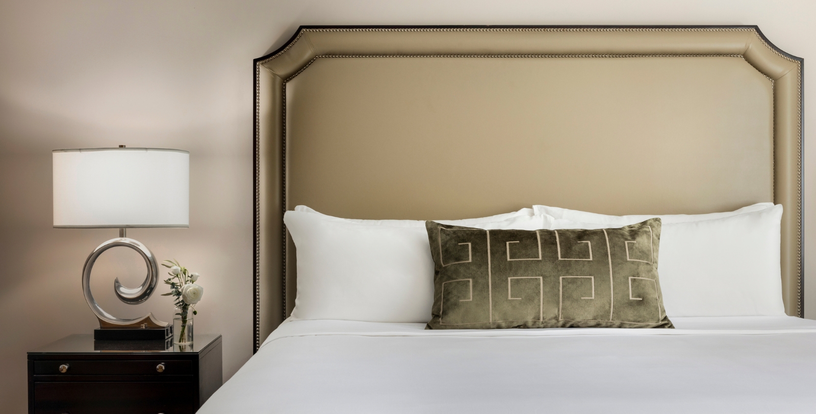 a bed with a pillow and a lamp on the side
