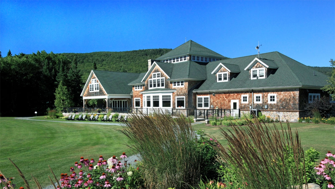 a large building with a lawn and lawn chairs