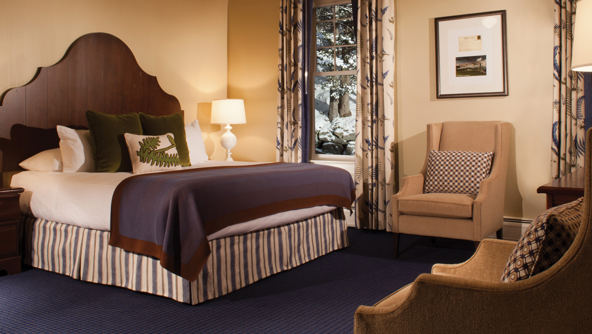 a room with a bed and chairs