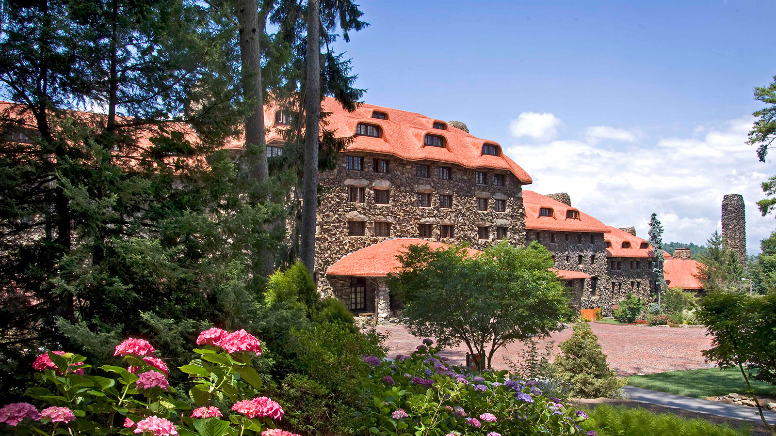 a large stone building with red roof with The Omni Grove Park Inn in the background