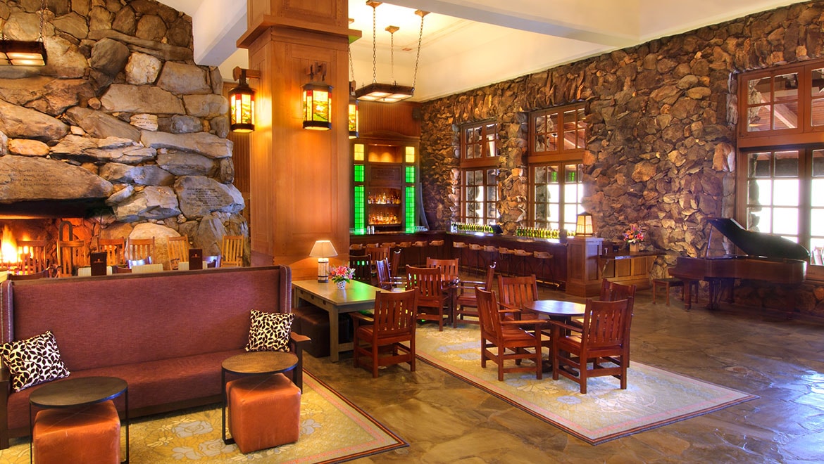 a room with a stone wall and a table and chairs