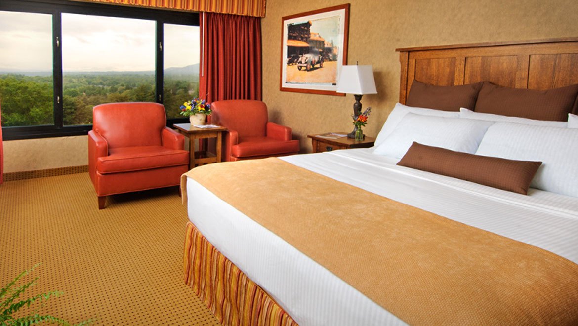 a hotel room with a bed and chairs