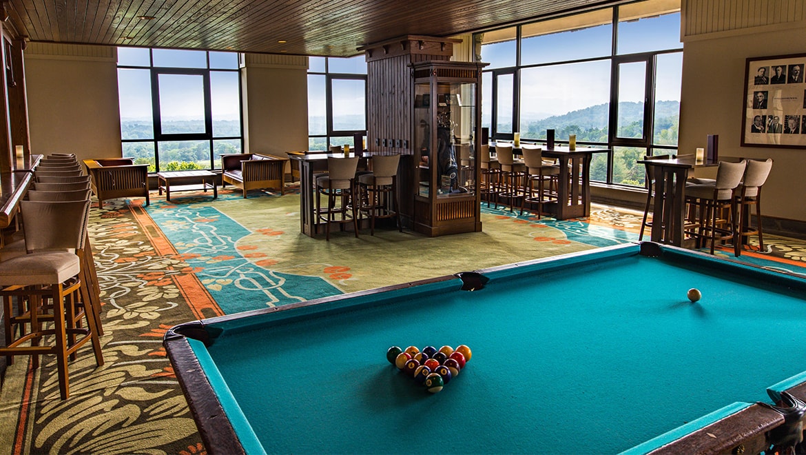 a pool table in a room with windows