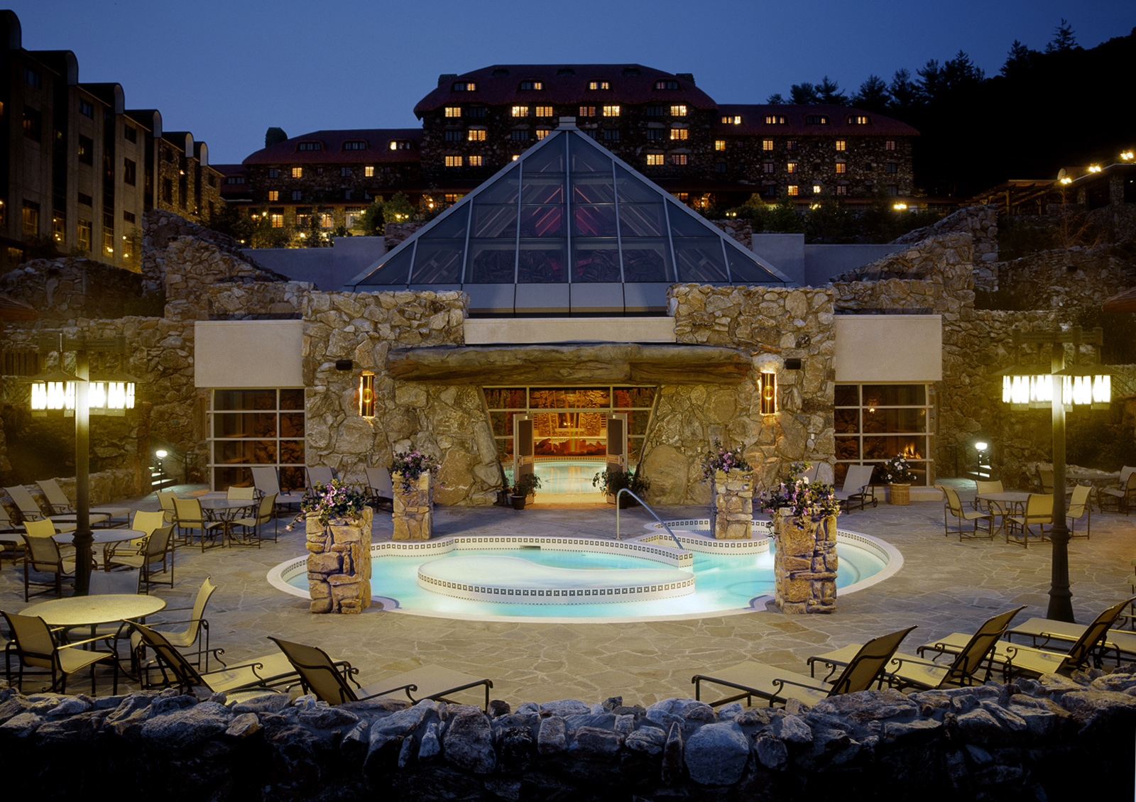 a pool with a glass roof and a building with a glass roof