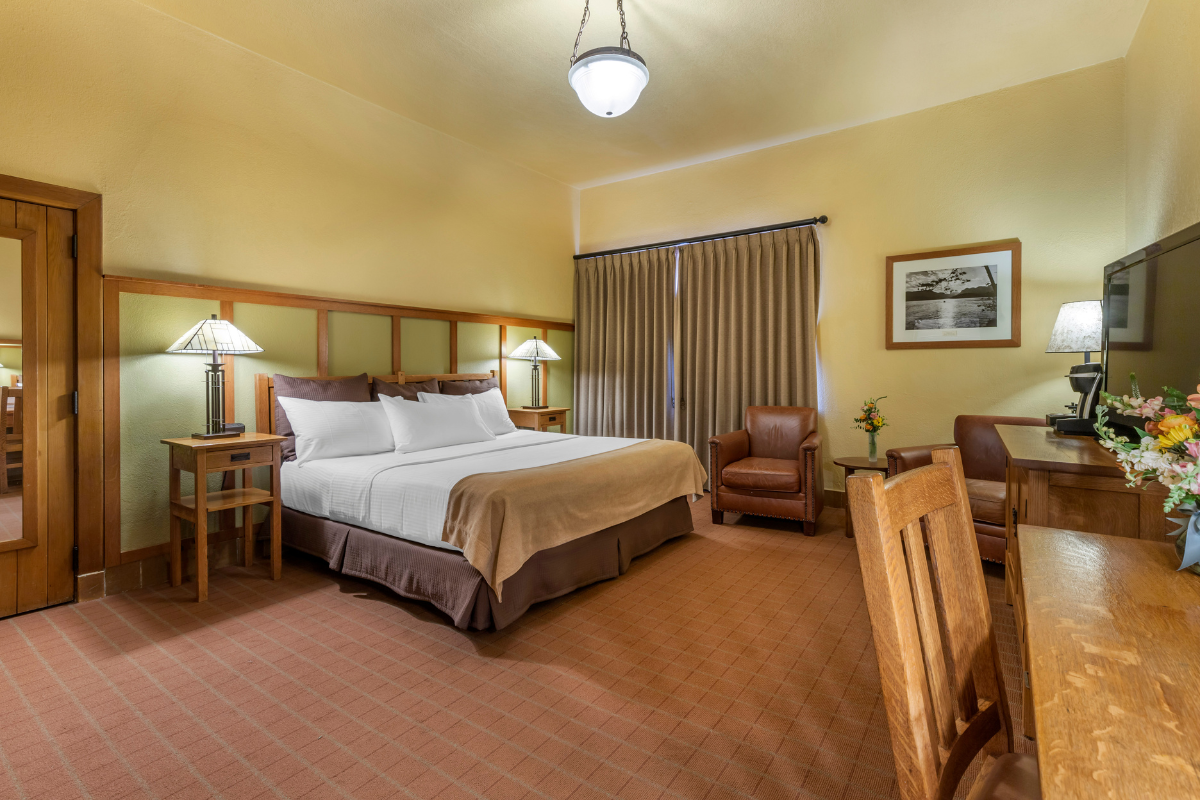 a room with a bed and chairs
