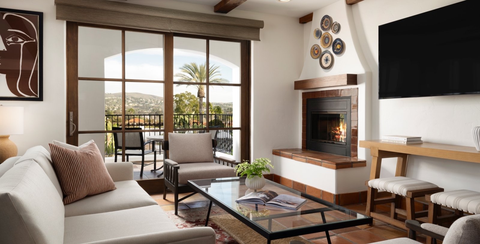 a living room with a fireplace and a glass coffee table