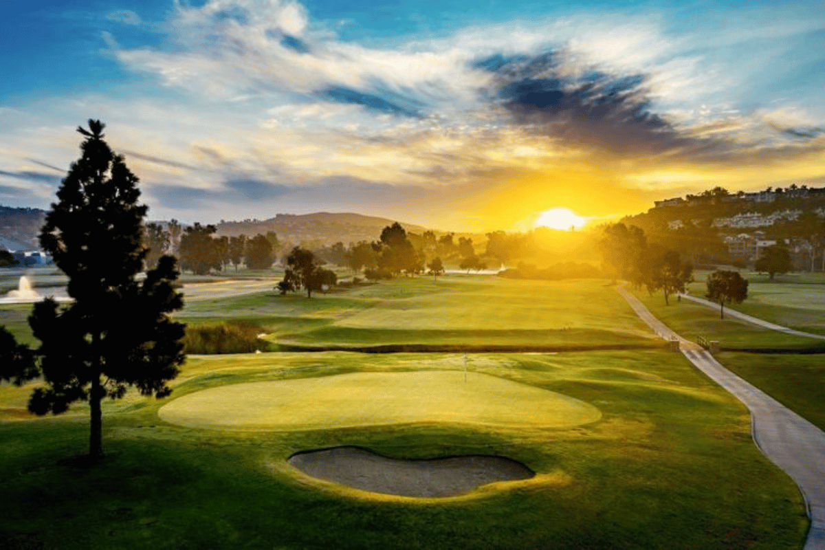 a golf course with a sunset