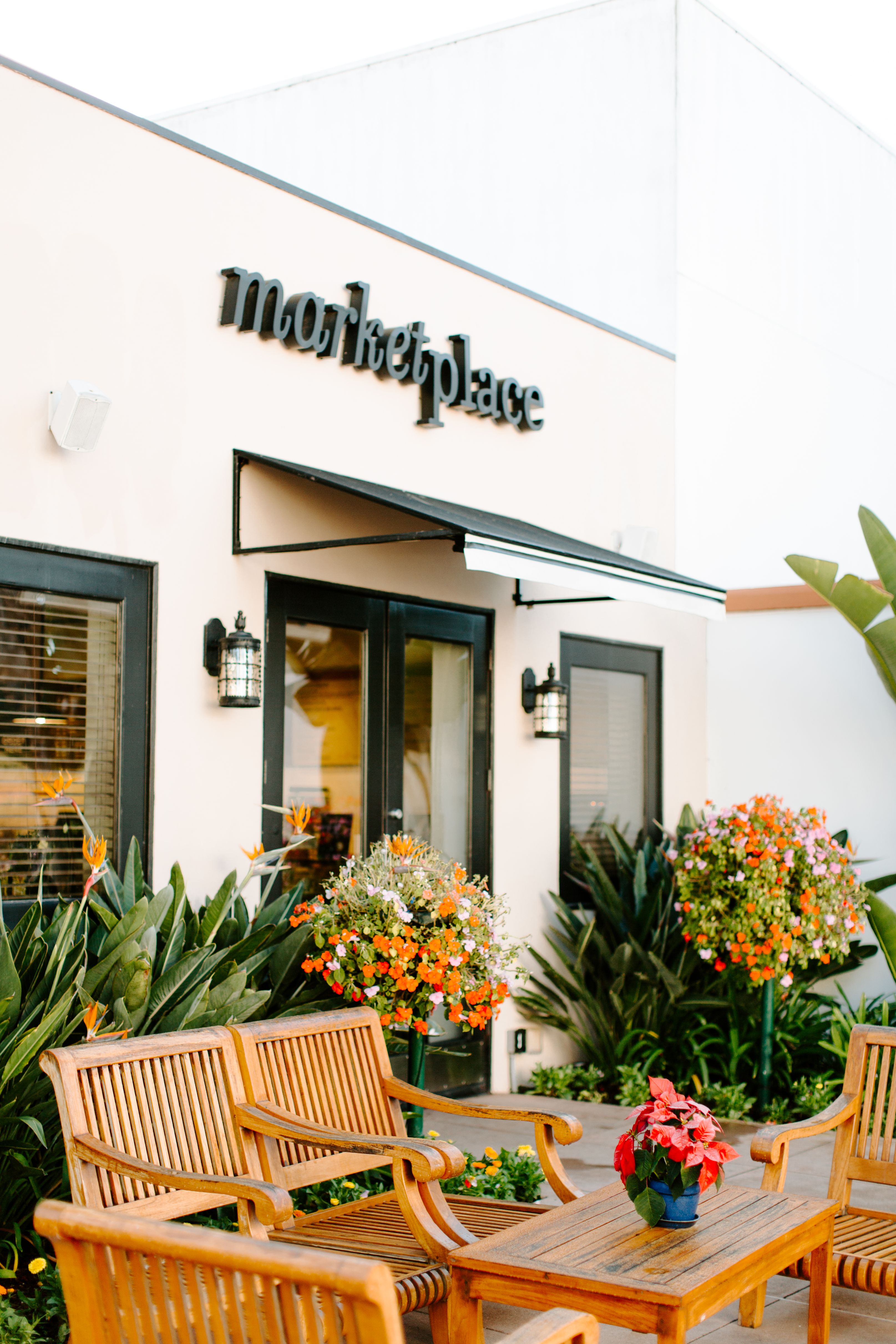 a store front with chairs and flowers