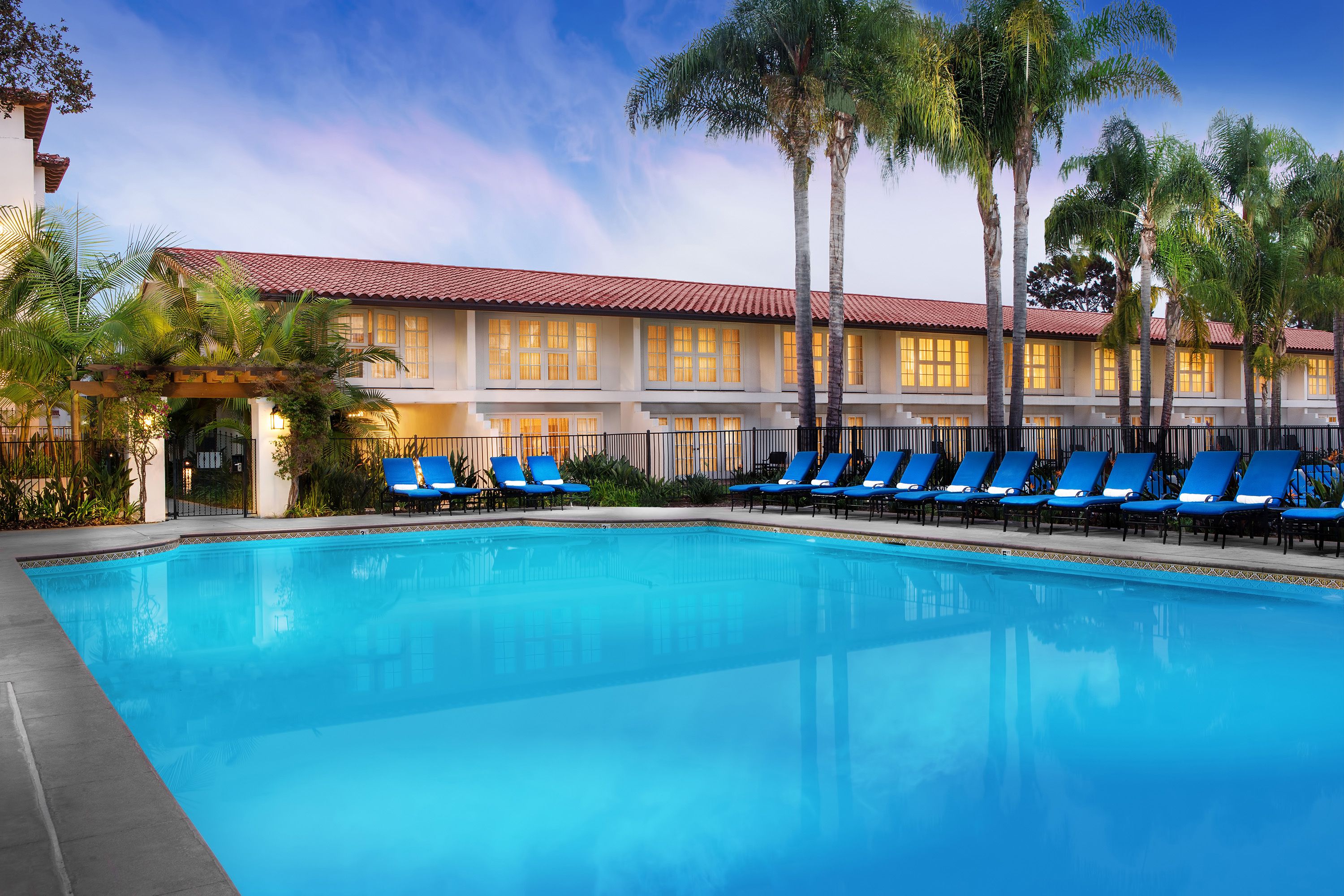 a pool with lounge chairs and palm trees