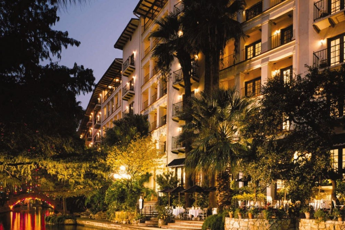 a hotel with palm trees and a pool