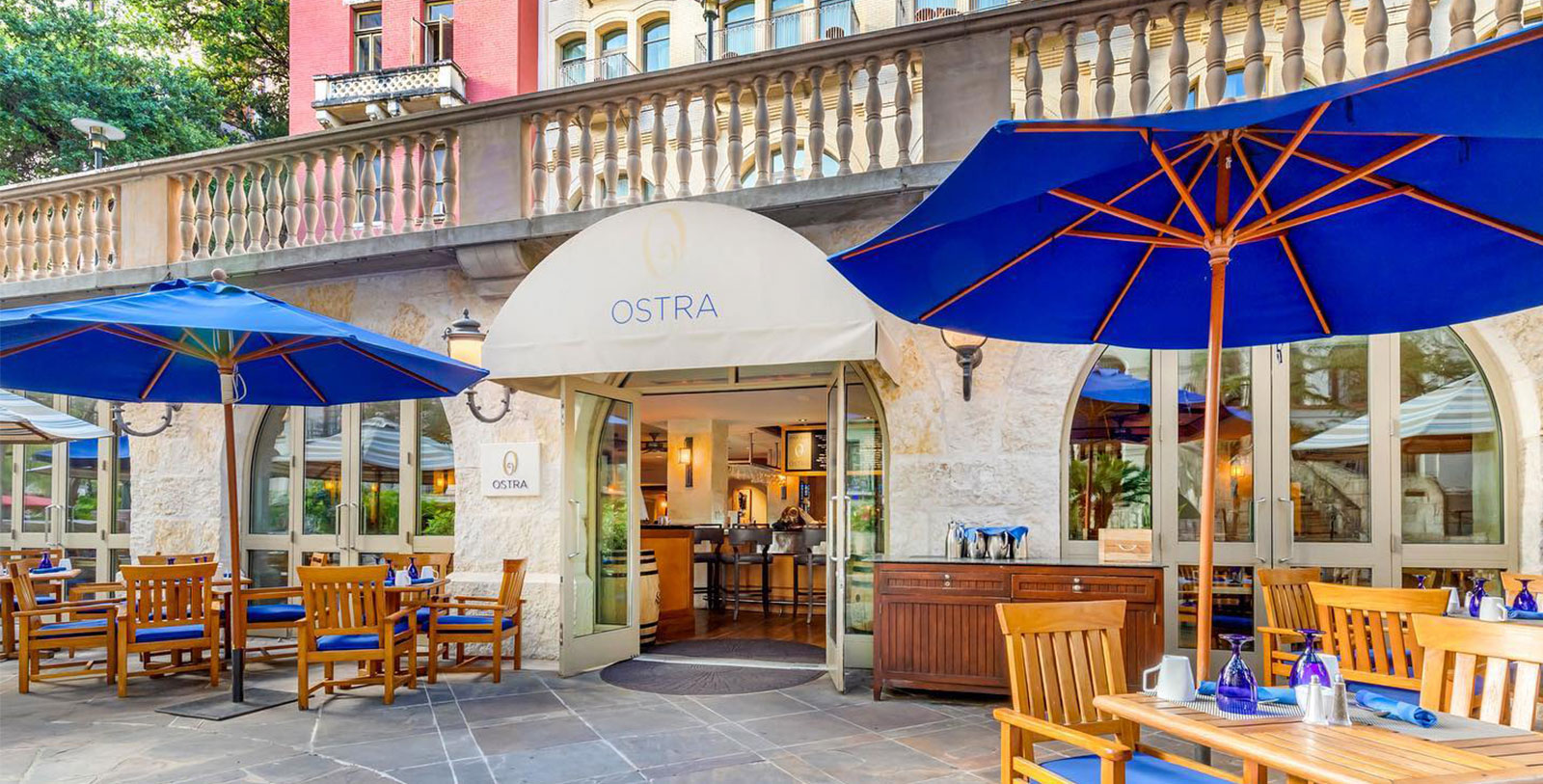 a restaurant entrance with umbrellas and tables
