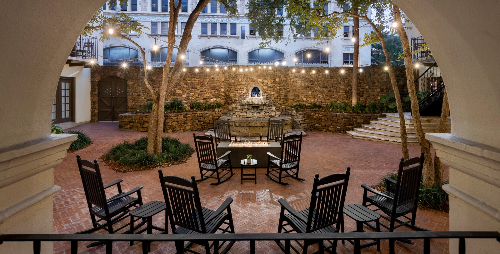 a patio with chairs and a fountain