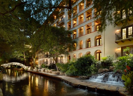 a building with a waterfall and trees