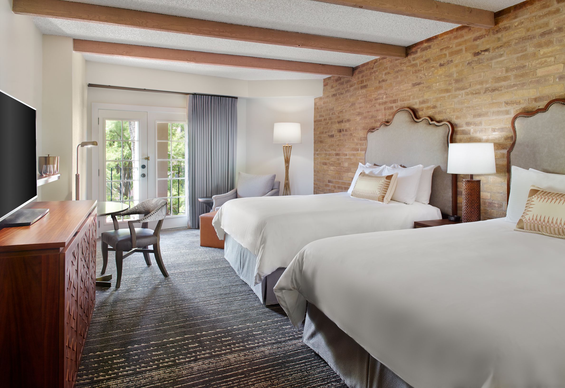 a room with two beds and a brick wall