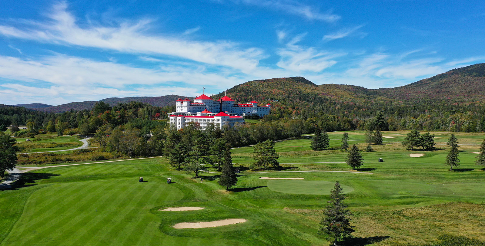 a golf course with a large building and trees