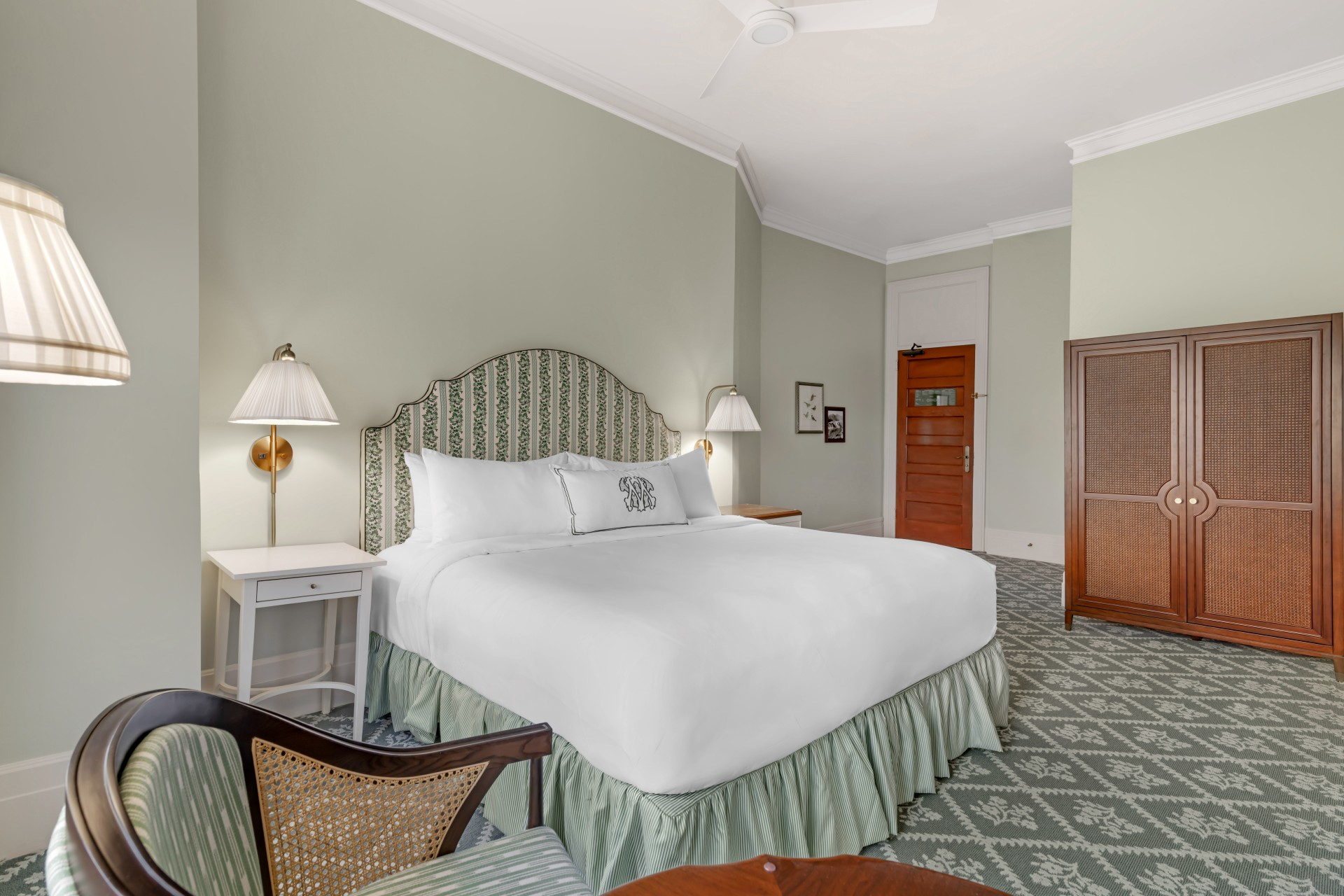 a room with a bed and chairs