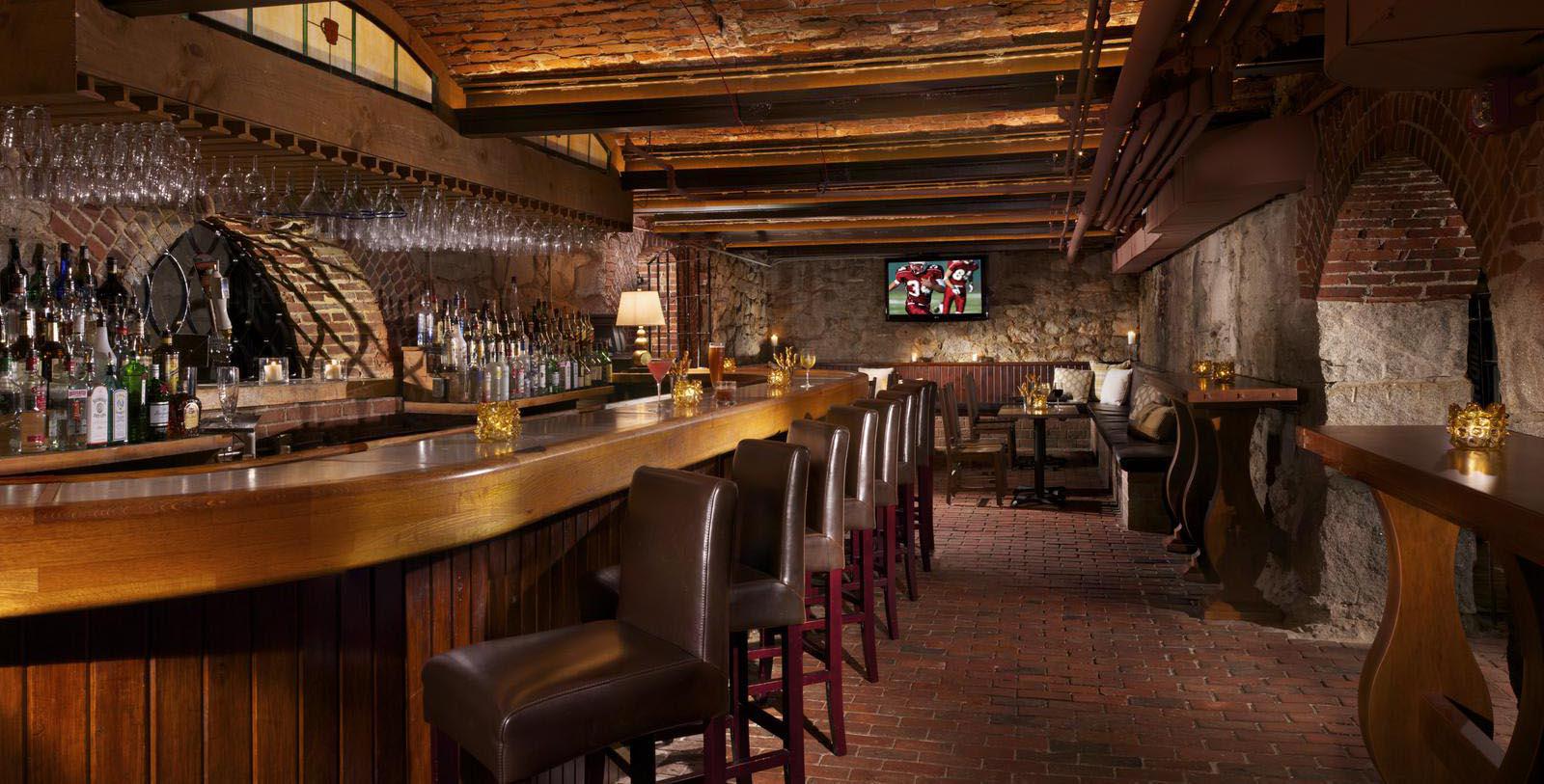 a bar with chairs and wine glasses