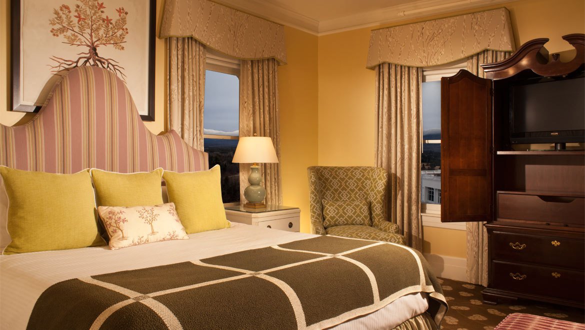 a bedroom with a bed and chairs