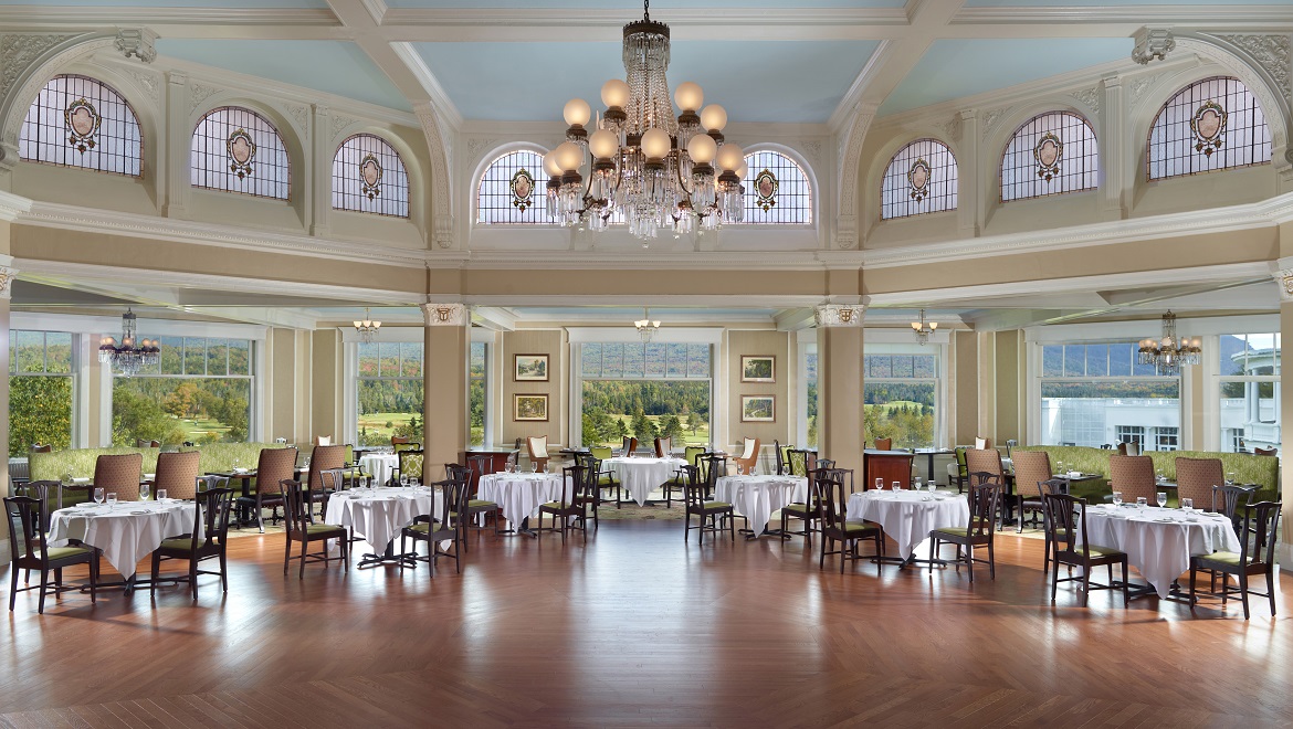 a room with tables and chairs and a chandelier