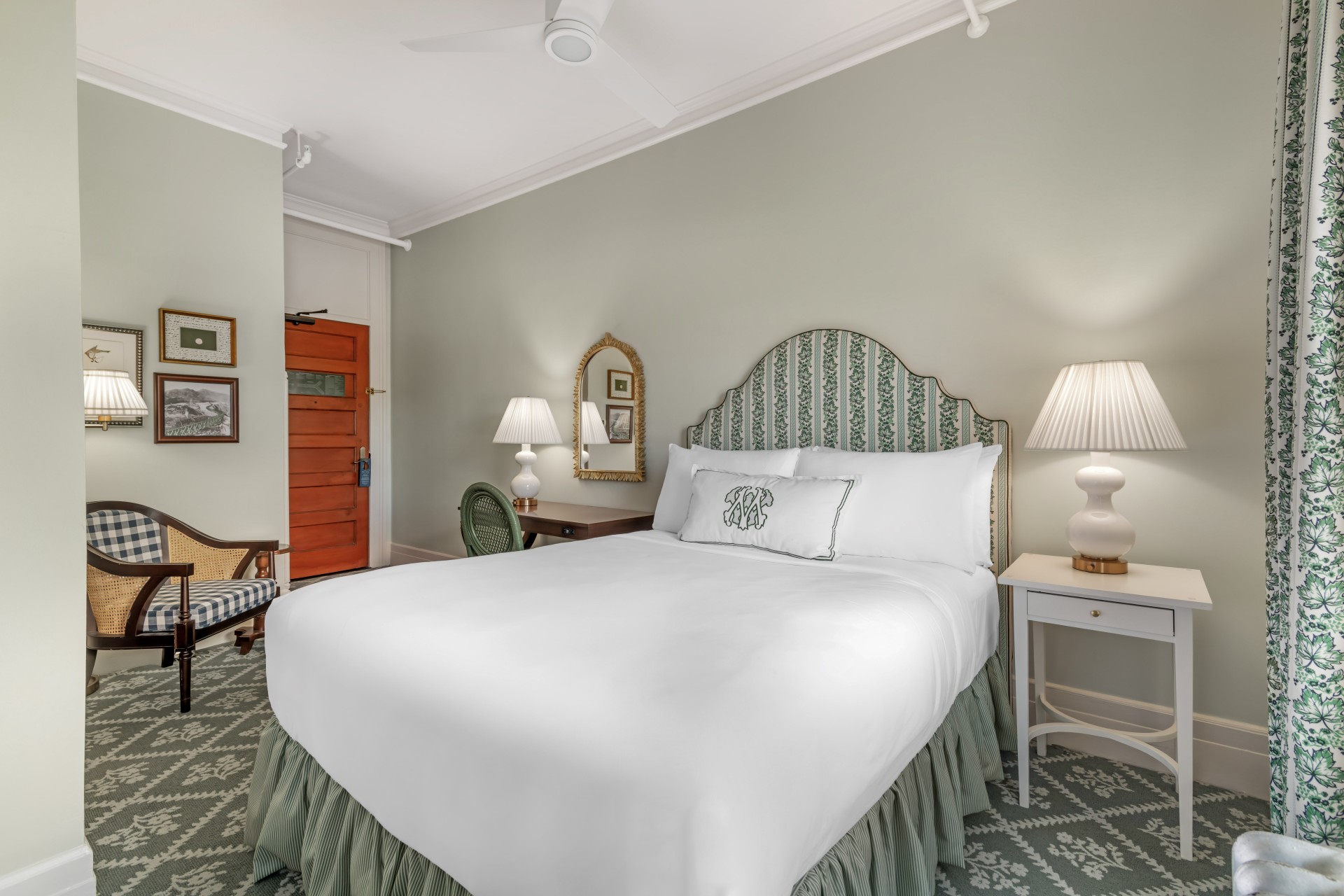 a bed with a green headboard and white lamps