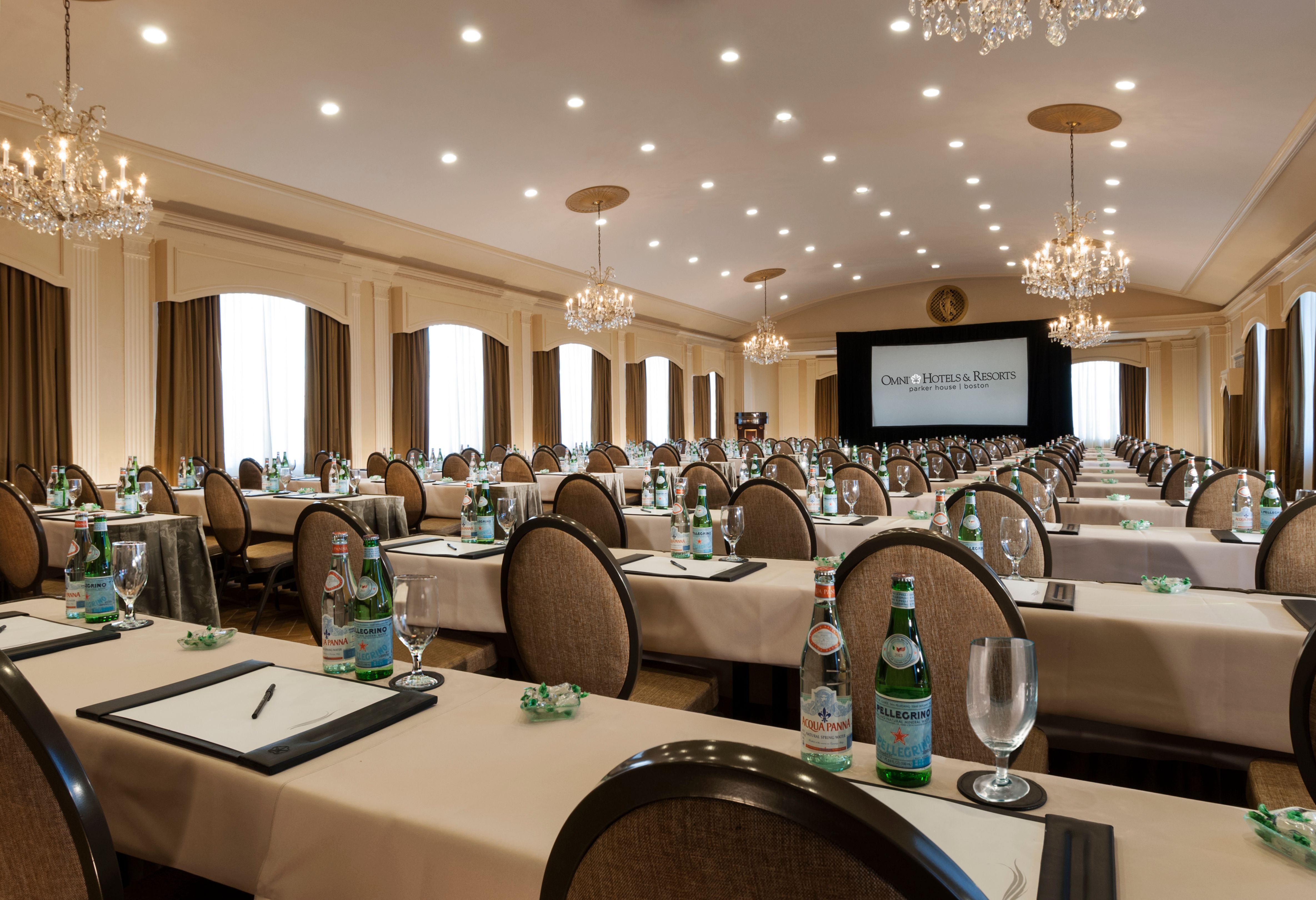 a room with tables and chairs and a projector screen