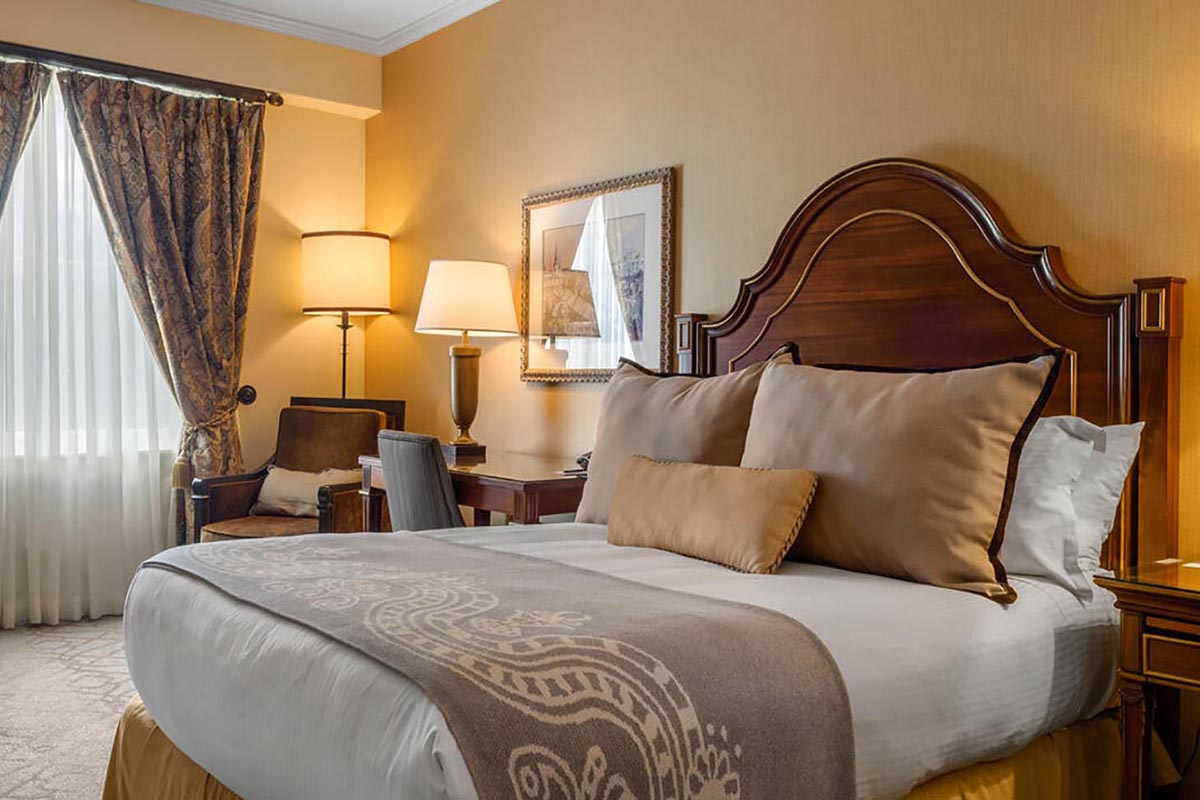 a bed with a wood headboard and a lamp in a room