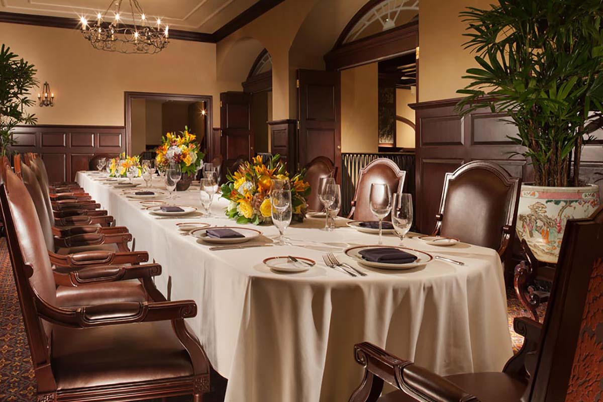 a long table with white tablecloth and plates and glasses