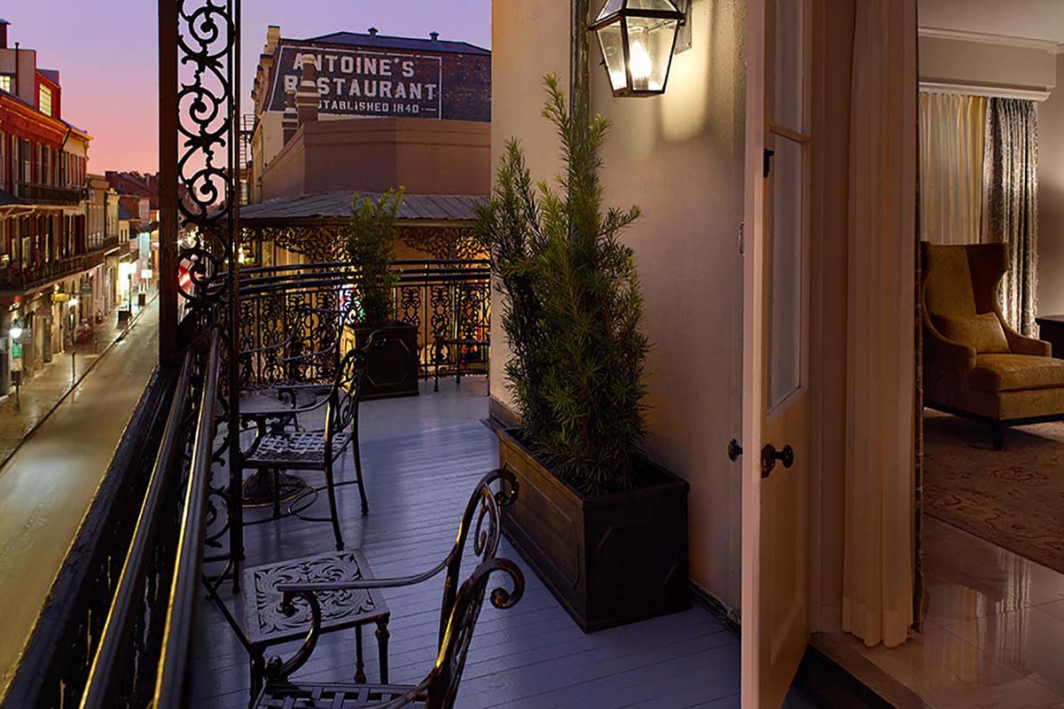a balcony with chairs and a plant