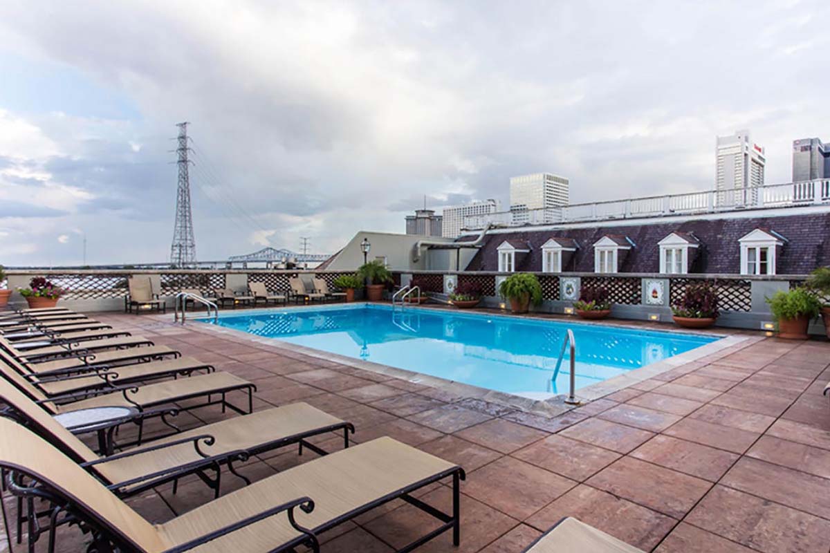 a pool with lounge chairs and a building in the background
