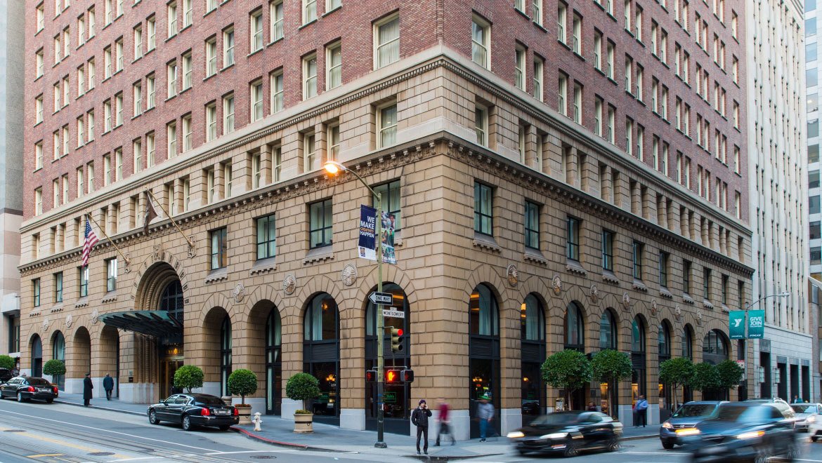 a building with many windows and cars on the corner