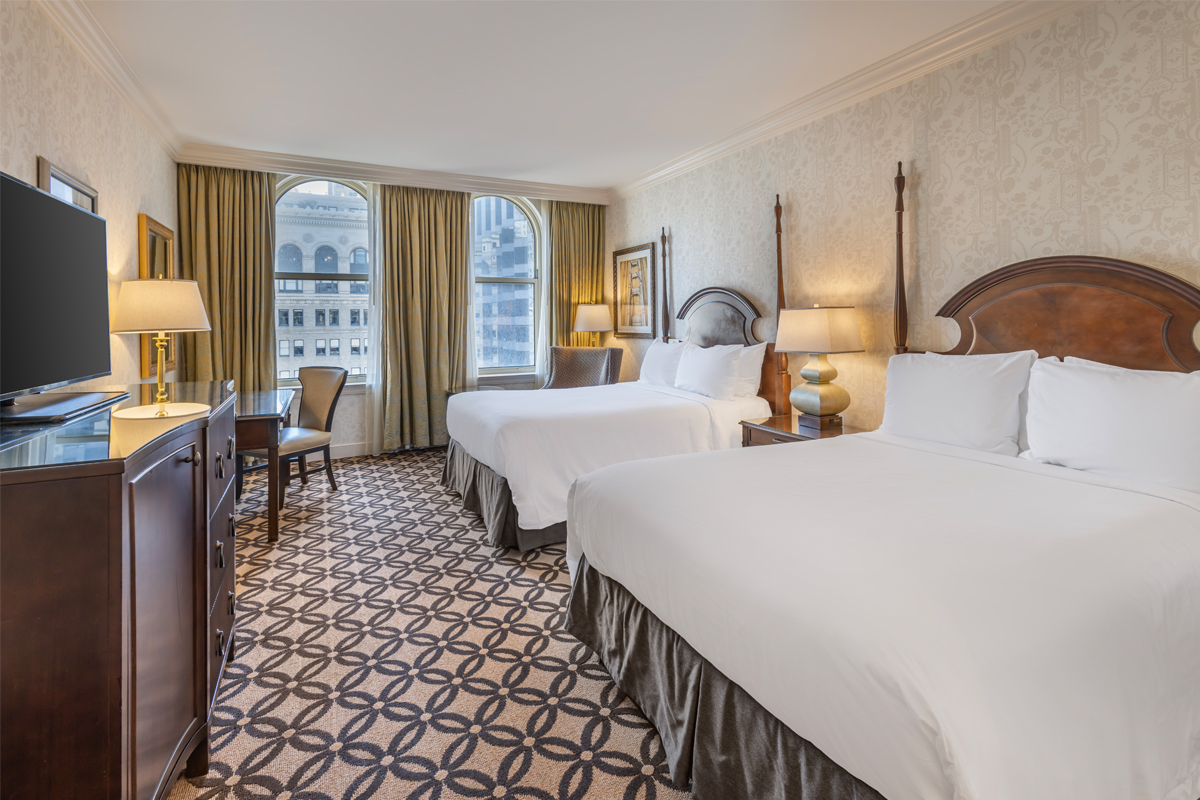 a room with two beds and a desk