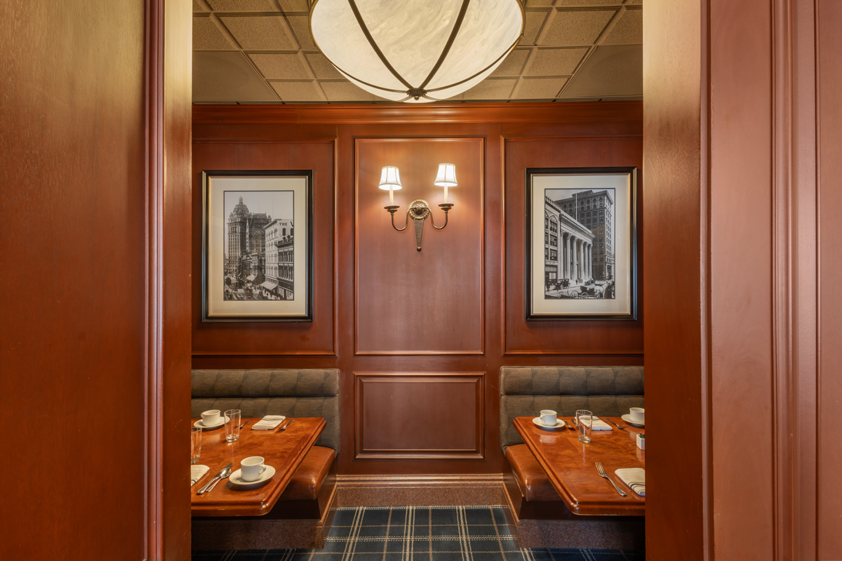 a booth seating with a chandelier and pictures on the wall