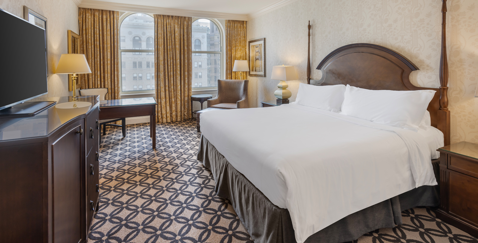 a hotel room with a bed and chairs
