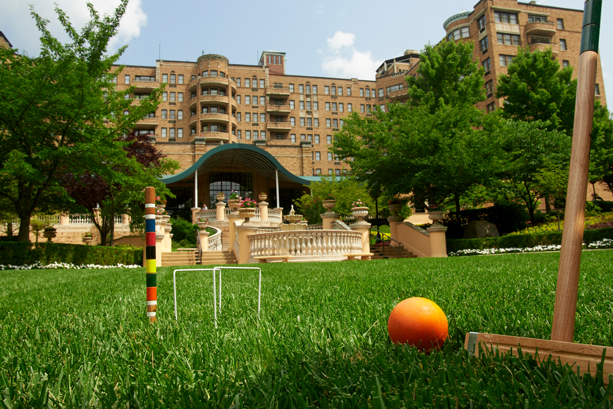 a lawn with a ball and orange in front of a building
