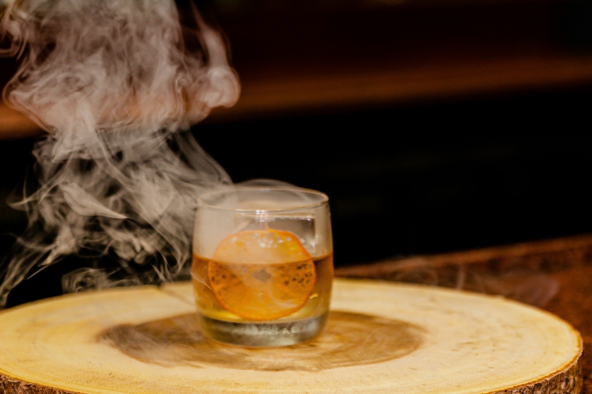a glass with liquid and smoke