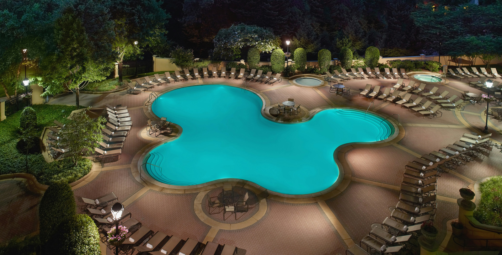 a pool with chairs and a tree
