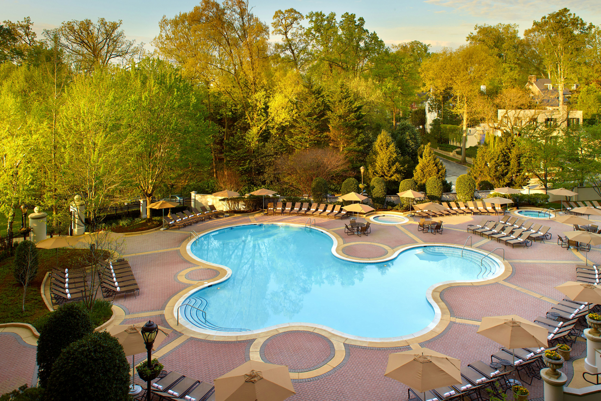 a swimming pool with chairs and umbrellas