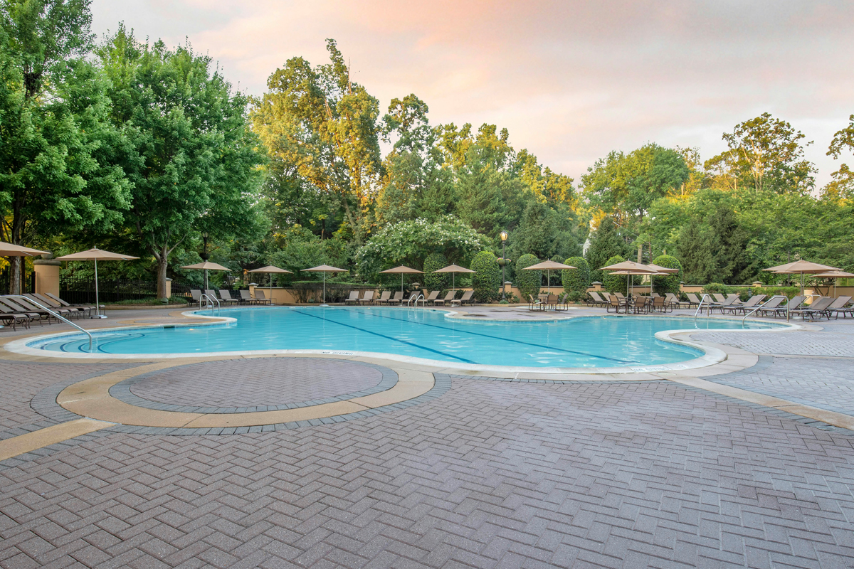 a pool with umbrellas and chairs in the middle