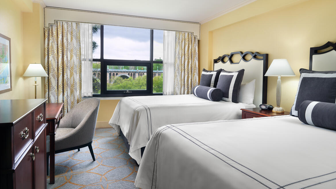 a room with two beds and a chair
