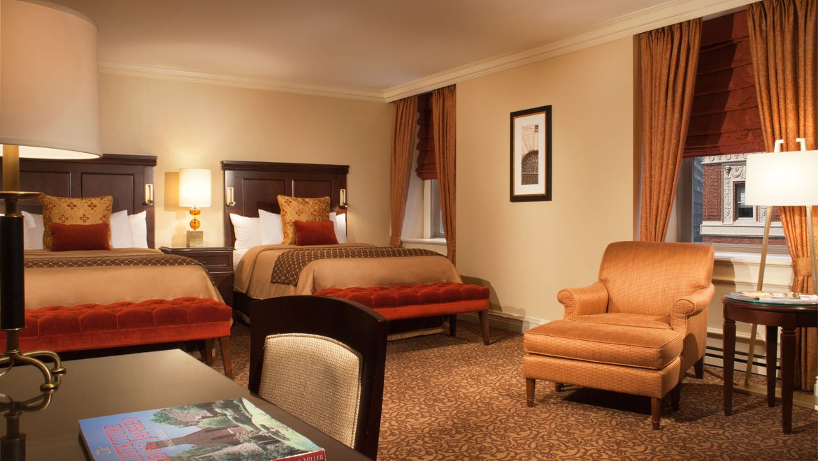 a room with a bed and chairs