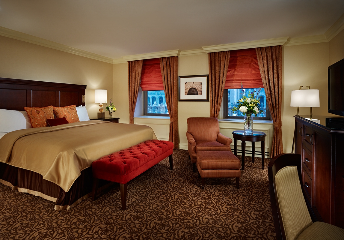 a bedroom with a bed and chairs