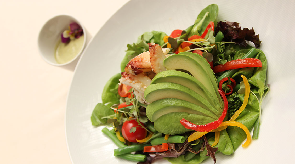 a plate of salad with avocado and vegetables