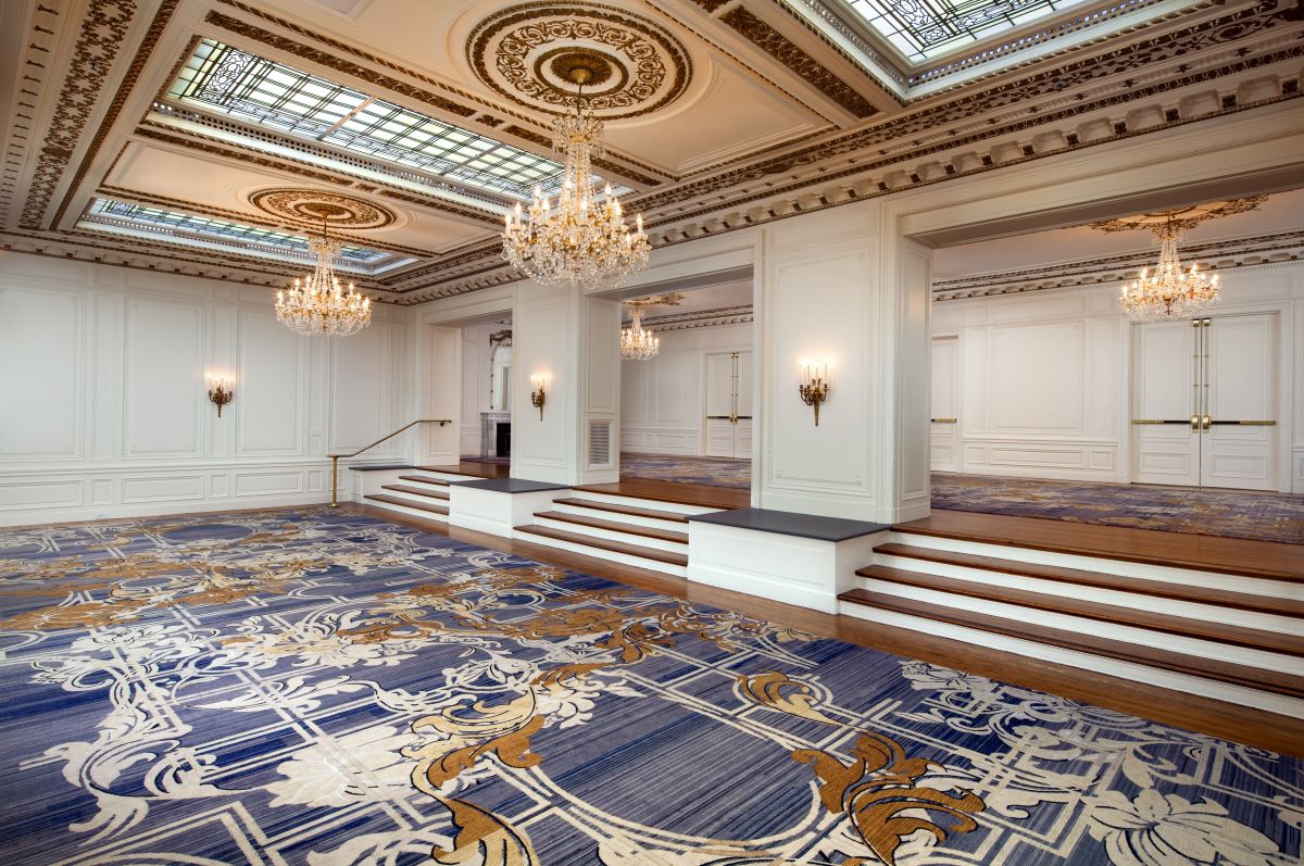 a large room with stairs and chandeliers