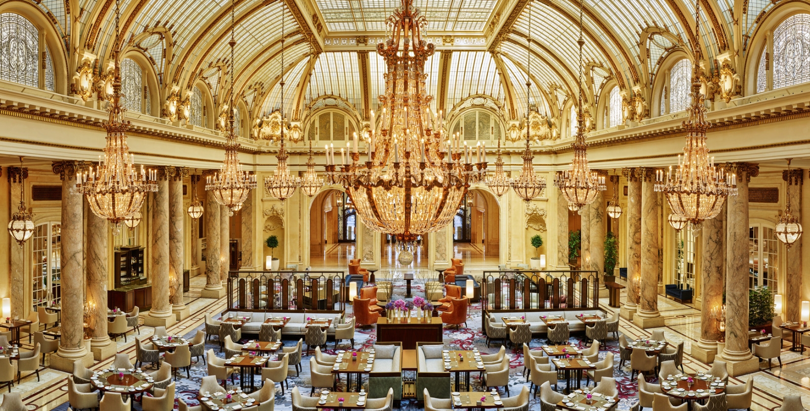 a large room with tables and chairs and chandeliers