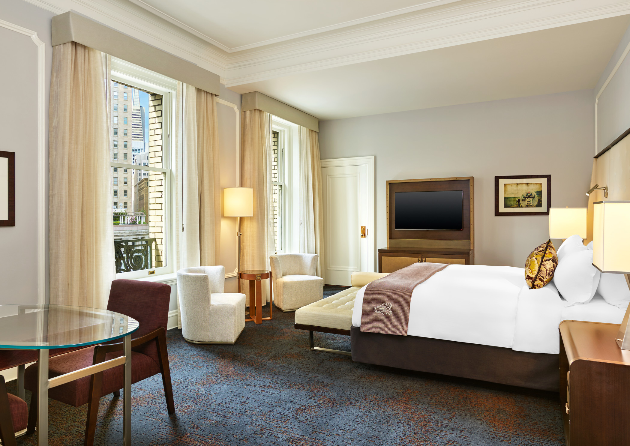 a room with a bed and chairs