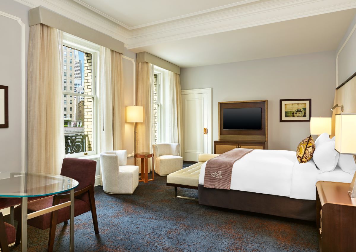 a room with a bed and chairs