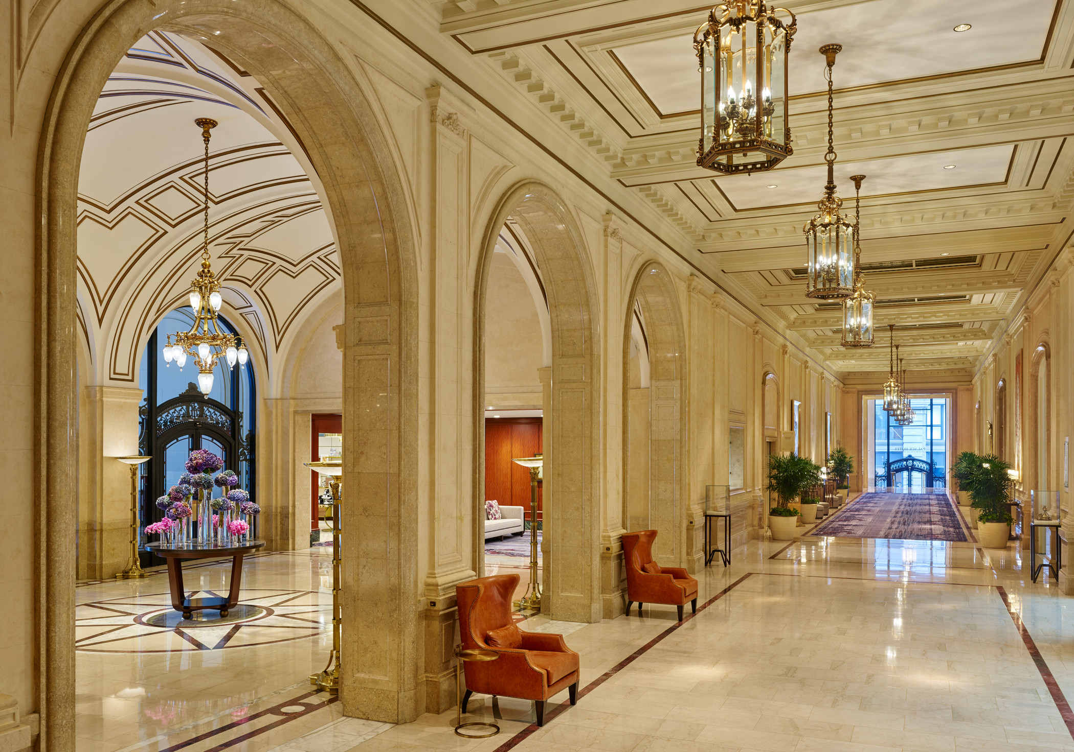 a large hallway with chairs and chandeliers